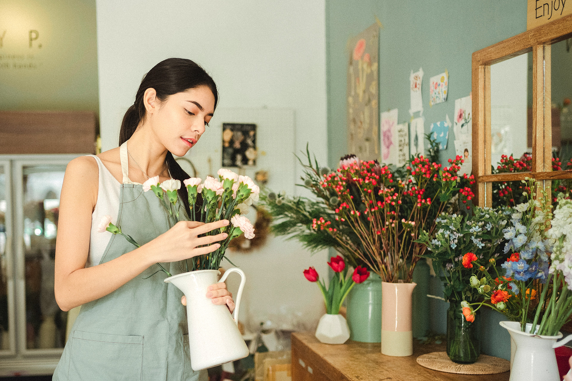 image of a dark haired woman working in  a flower shop